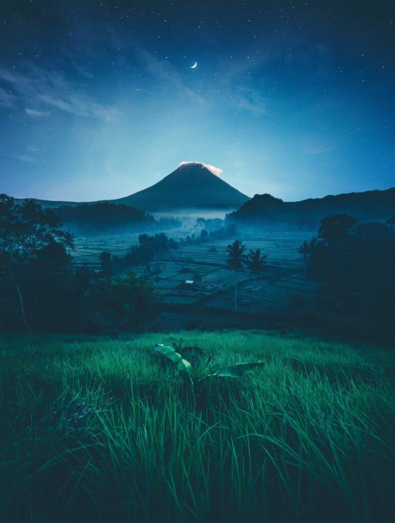 Une image d'une montagne la nuit avec un champ vert, permettant à la fois détente et bien-être.