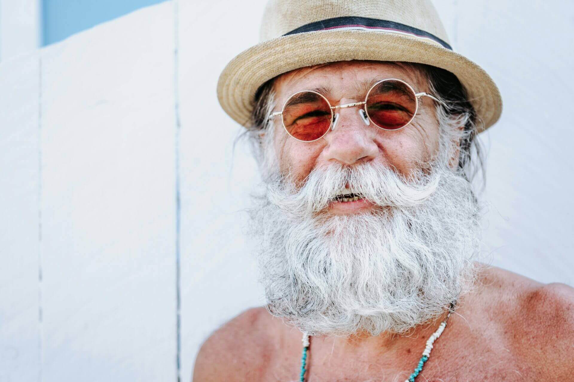 Un vieil homme avec une barbe et des lunettes qui combat son stress par le sourire