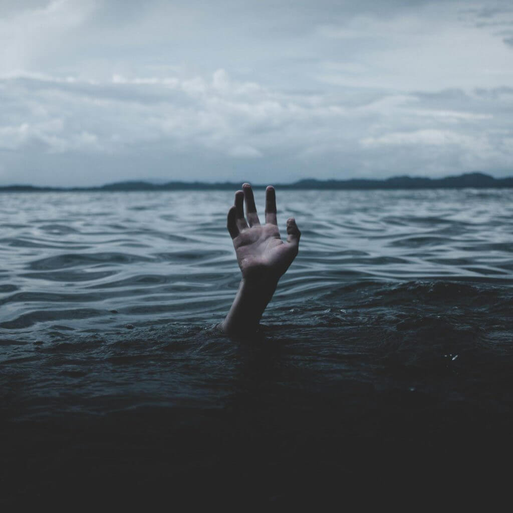 Une main faisant surface d’un plan d’eau, induisant un sentiment d’hypnose et soulageant l’anxiété et la détresse.