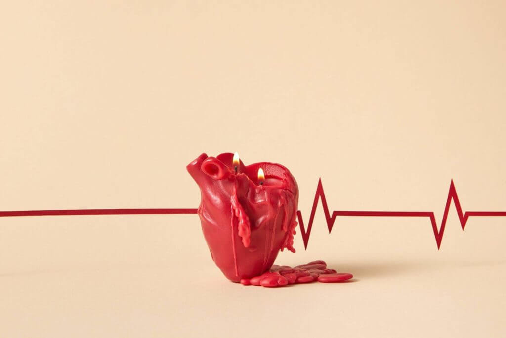 Une bougie rouge allumée en forme de cœur, favorisant la cohérence cardiaque.
