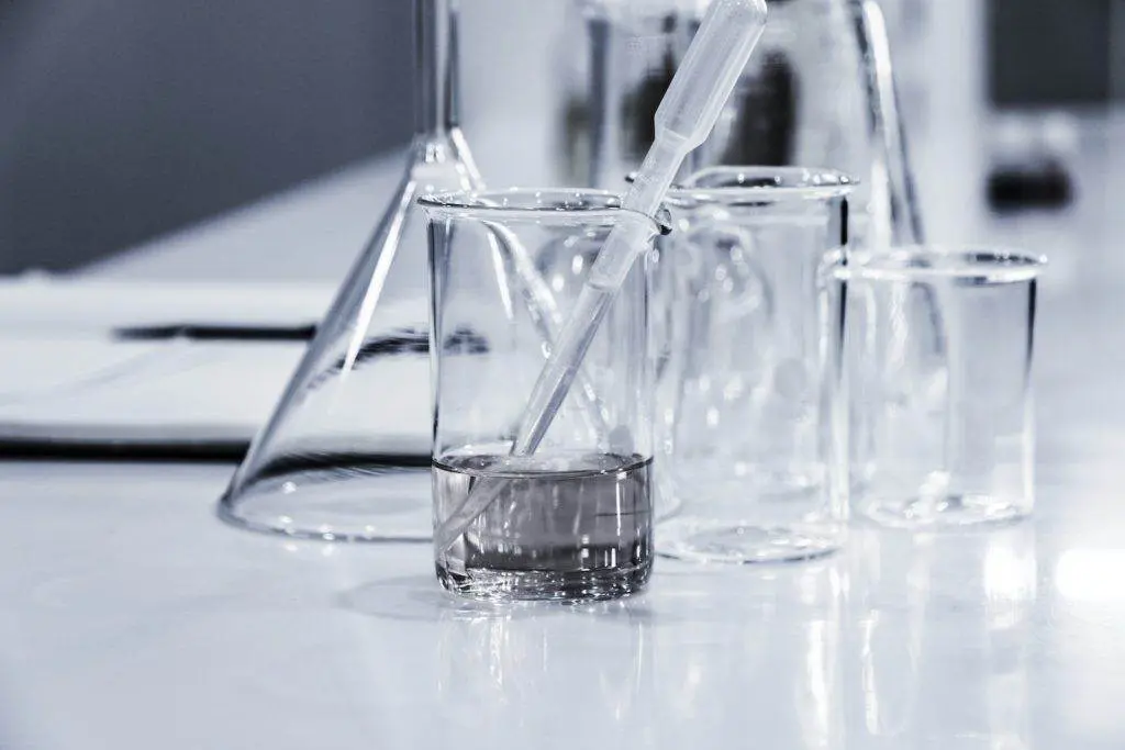 Un verre de liquide dans un bécher en verre sur une table à des fins de maigrir ou d'hypnose.