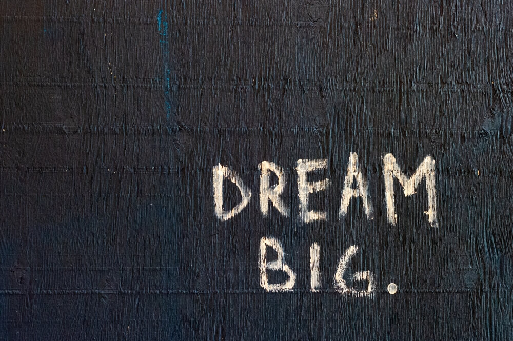 Le mot rêve lucide écrit sur un mur noir.