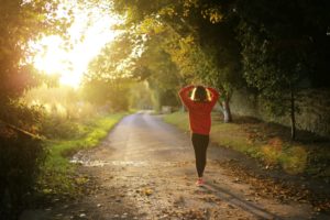 Une femme stressée court sur une route de campagne.