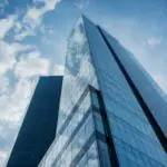 Un grand bâtiment de verre sur un ciel bleu.