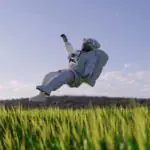 Un homme en combinaison spatiale volant à travers un champ d’herbe.