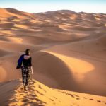 Une femme debout au sommet d'une dune de sable dans le désert du Sahara.